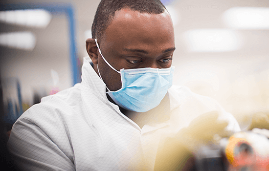 Laboratoriossa työskentelevä maskia käyttävä mies